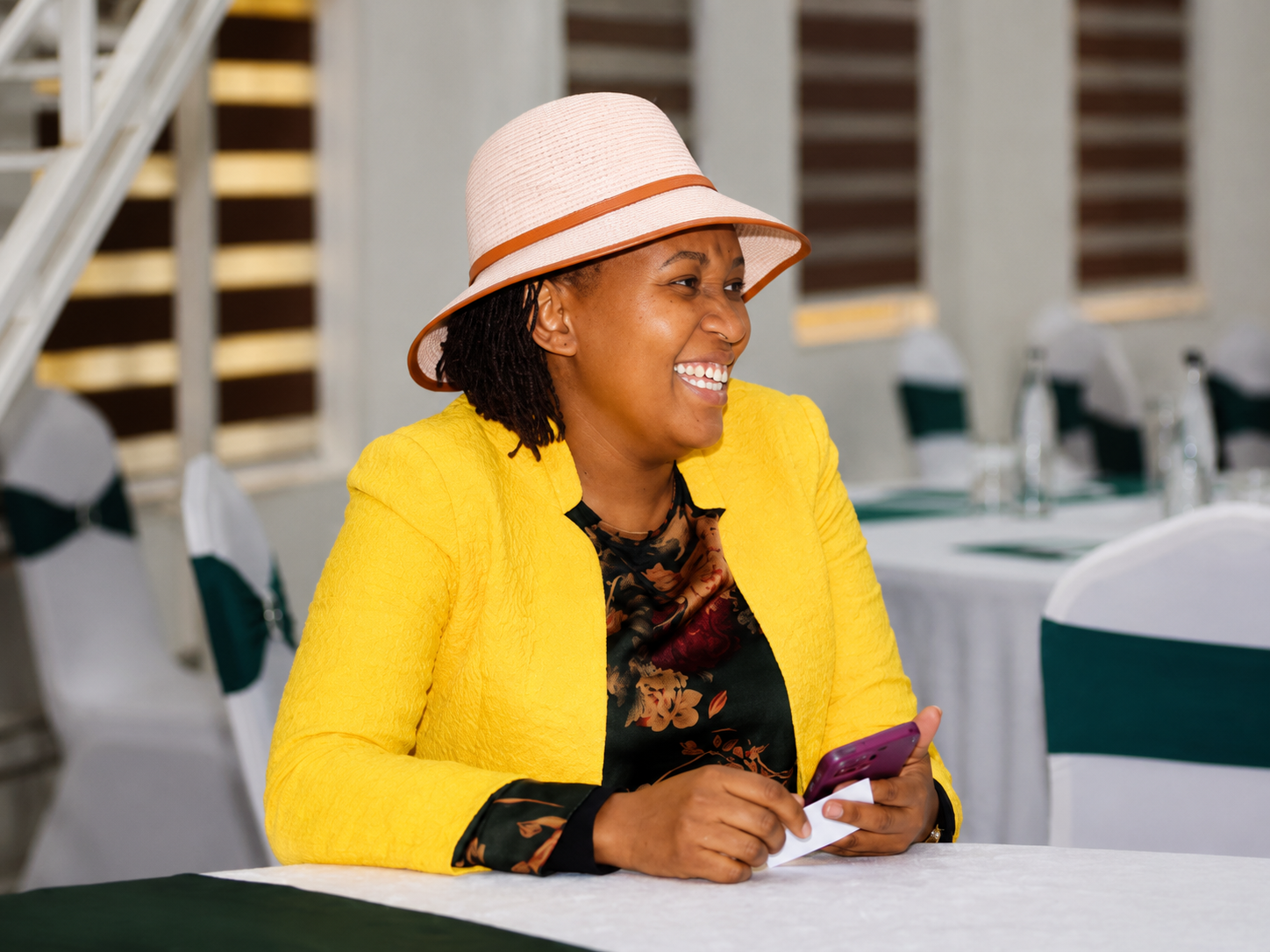 Wanjiru Kibe smiling while seated at the forum in Kitengela