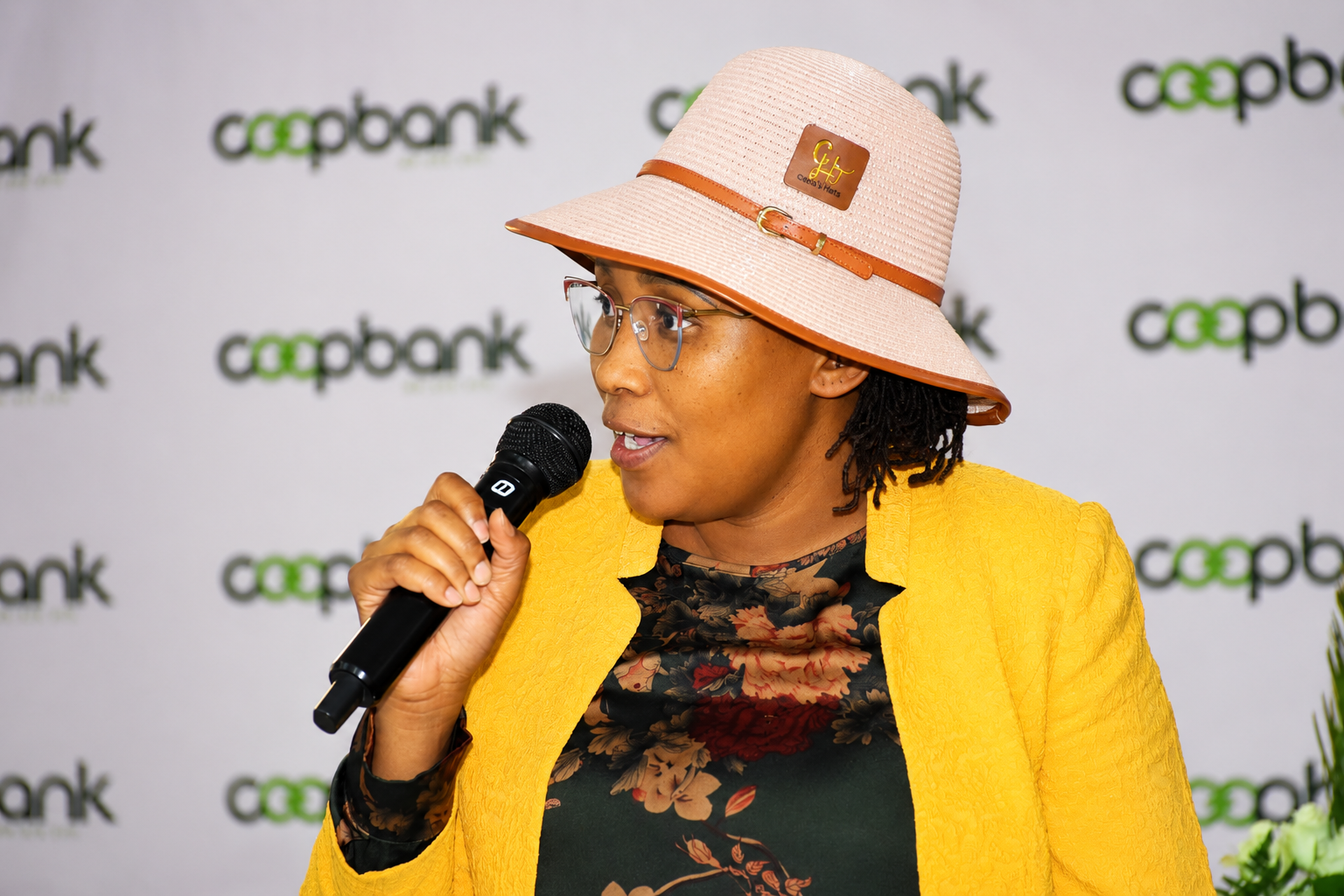 Wanjiru Kibe speaking at the microphone during the business forum